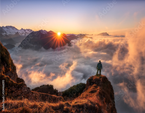 One man standing on mountain peak over the clouds photo