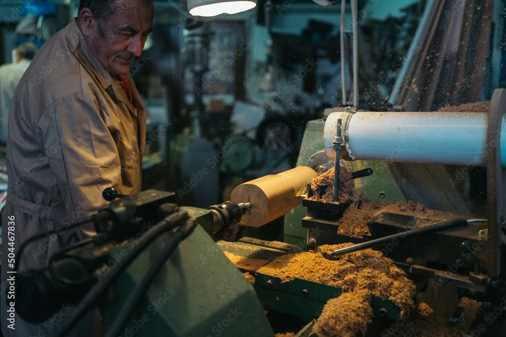 Woodworker carving wood on lathe machine Woodworker carving wood on lathe machine
