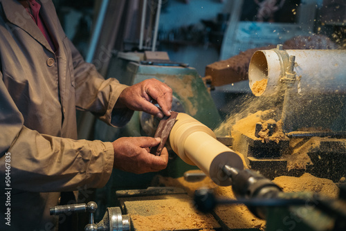 Carpenter using lathe machine for grinding photo