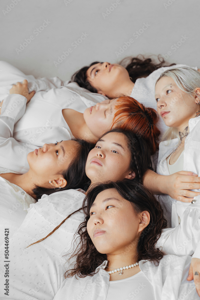 young asian women lie on the floor together young asian women lie on the floor together