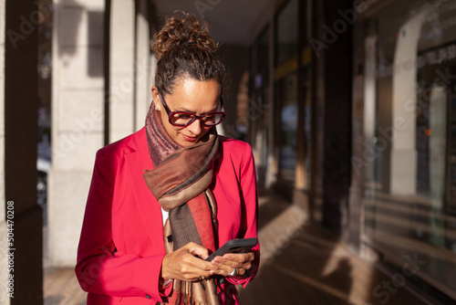 mature business woman using smartphone in the city photo