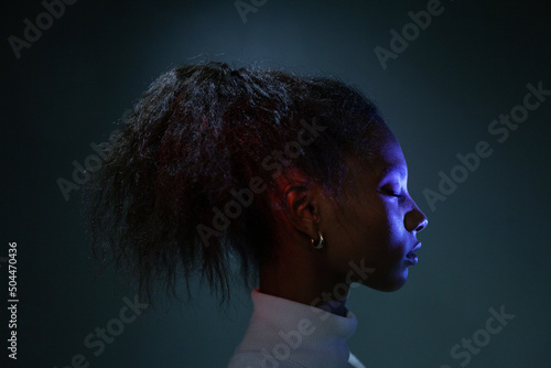 calm black woman with closed eyes, female face in profile, dark photo