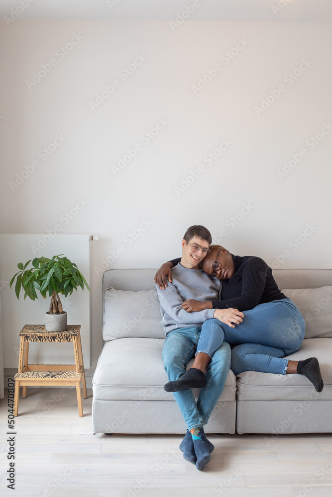 love, happy smiling mixed couple sitting together on couch in new home love, happy smiling mixed couple sitting together on couch in new home