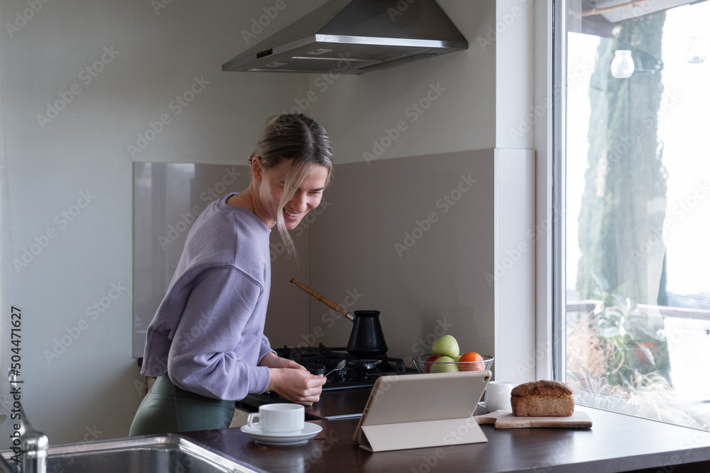Cheerful female checking recipe on tablet Cheerful female checking recipe on tablet