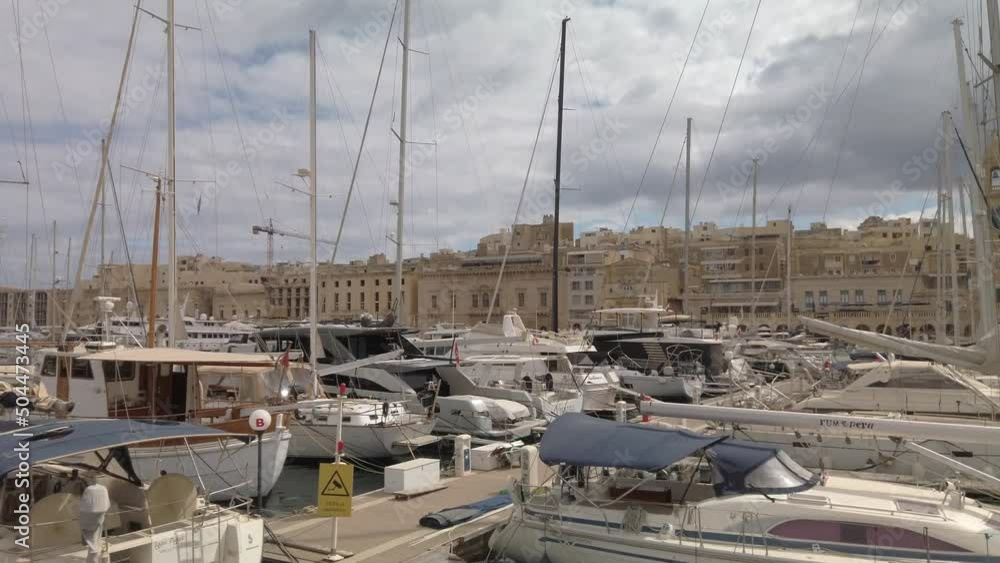 Sailing past Vittoriosa waterfront with boats moored in the waterway Sailing past Vittoriosa waterfront with boats moored in the waterway