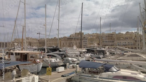 Sailing past Vittoriosa waterfront with boats moored in the waterway photo