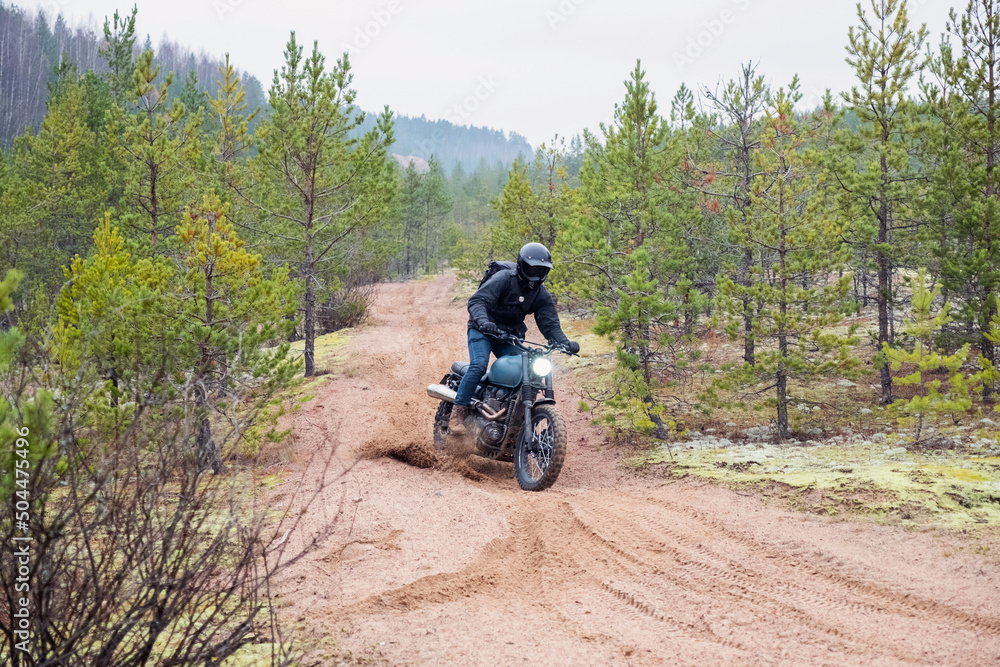 Rider rides on the classic motorcycle on the sand Rider rides on the classic motorcycle on the sand