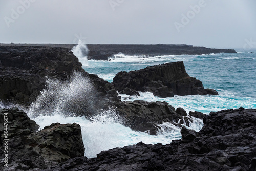 The coastal cliffs near Brimketill rock pool on a stormy day, with huge sea waves crashing against the black basalt rocks, Reykjanes peninsula, Iceland