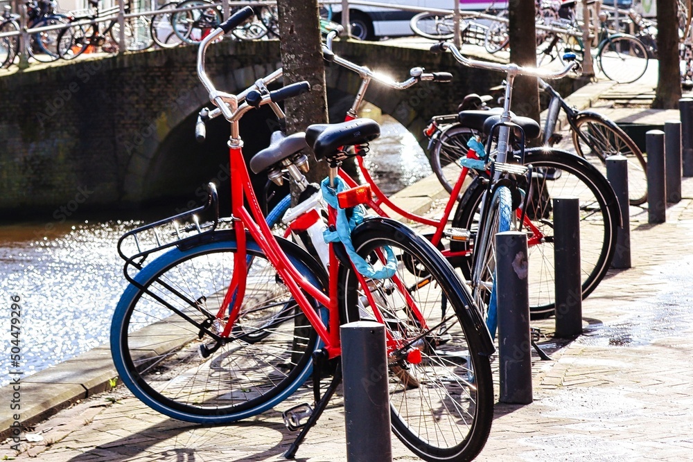 Red bicycles parked along canal in Amsterdam, Netherlands