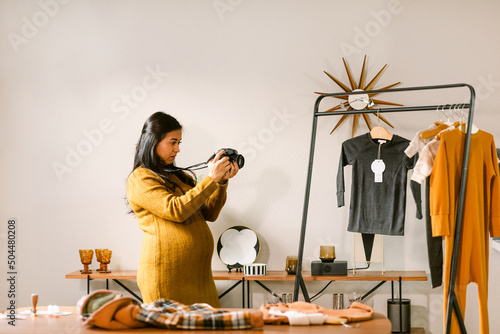 Prenatal entrepreneur taking photos of kids clothes