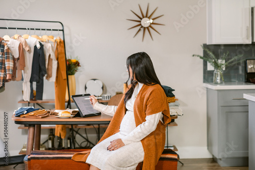 Pregnant business woman using tablet in loft photo
