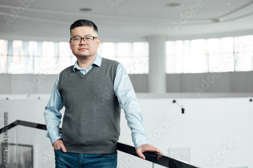 Portrait of Chinese man standing in office