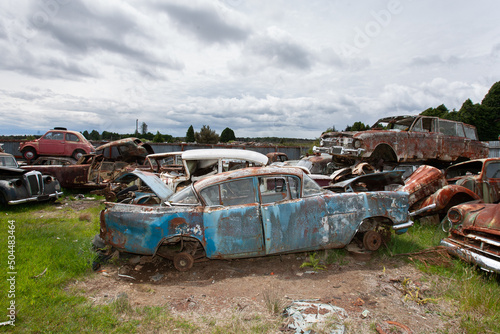 Ruined classic cars at a dumping yard photo