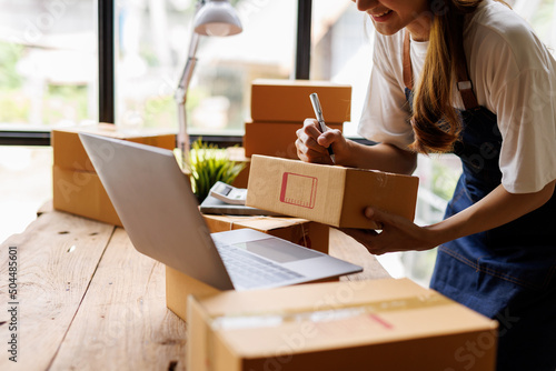 Busy young Asian entrepreneur woman checking product on stock take note with clipboard. Businesswoman working SME online at home. Small business owner start up freelance SME concept.