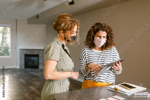 Realtor showing tablet to broker in house for sale photo