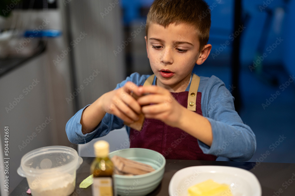 Boy preparing chocolate bar for making dessert Boy preparing chocolate bar for making dessert