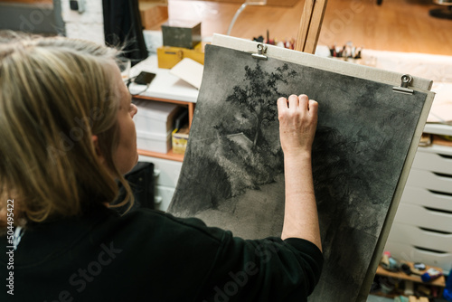 Talented artist drawing with charcoal on canvas photo
