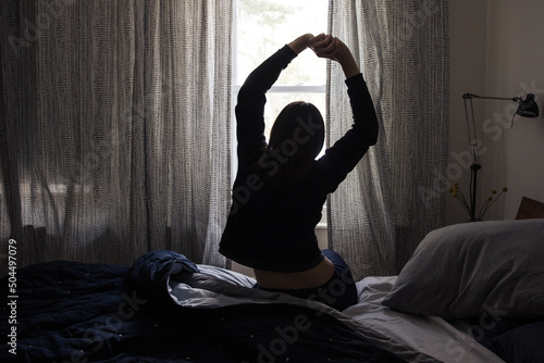 Woman stretching in bed