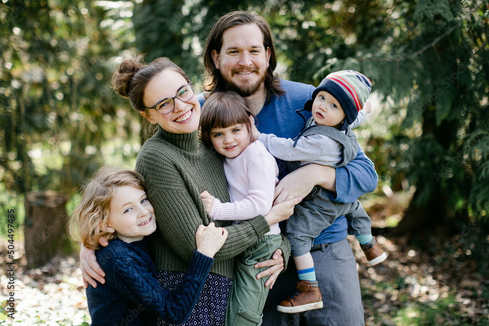 Happy Family Hugging Each Other for Portrait in Park Happy Family Hugging Each Other for Portrait in Park