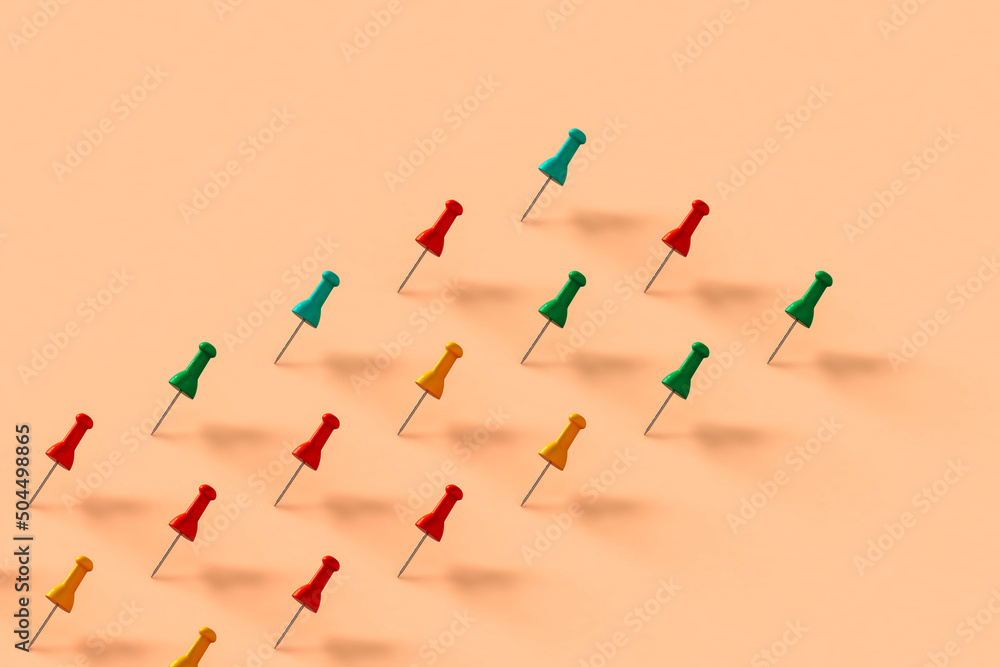 a row of colorful push pins on pink background a row of colorful push pins on pink background