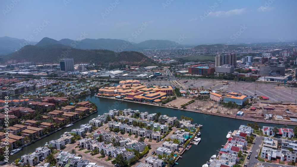 Obraz premium aerial drone shots of the beach city of Lechería, with a residential area of Venice-style stilt houses, you can see houses, editions, canals, houses on the sea, stilt houses, parking lots, swimming po