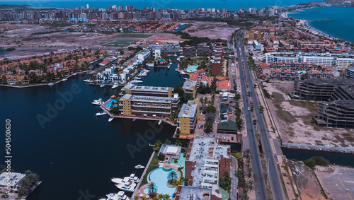 aerial drone shots of the beach city of Lecher  a  with a residential area of Venice-style stilt houses  you can see houses  editions  canals  houses on the sea  stilt houses  parking lots  swimming po
