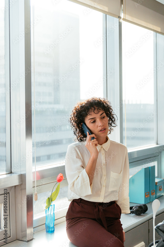 woman talking on smartphone at office woman talking on smartphone at office
