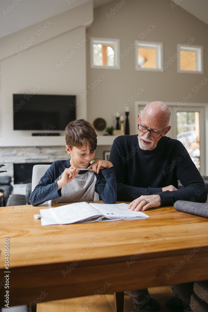 Mature man helping kid with schoolwork Mature man helping kid with schoolwork
