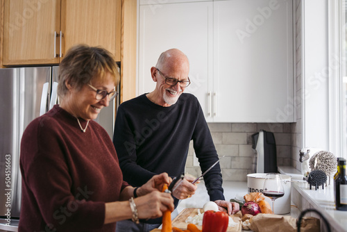 Mature couple making meal together.