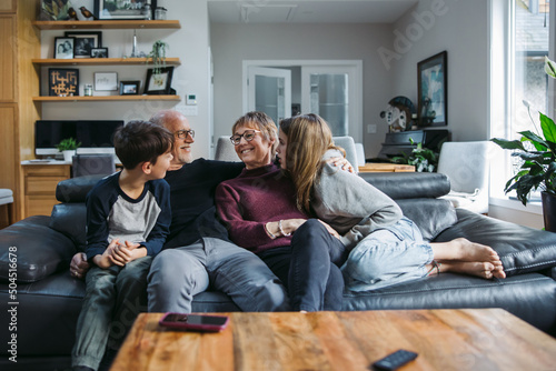Grandparents and grandkids cudding on the couch.