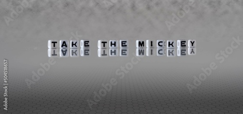 take the mickey word or concept represented by black and white letter cubes on a grey horizon background stretching to infinity