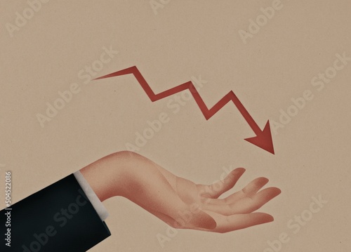 The businessman's hand holds a red falling arrow