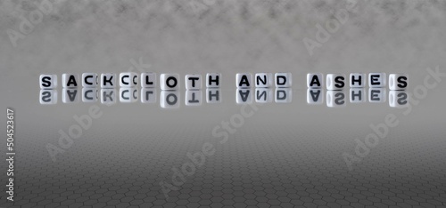 sackcloth and ashes word or concept represented by black and white letter cubes on a grey horizon background stretching to infinity