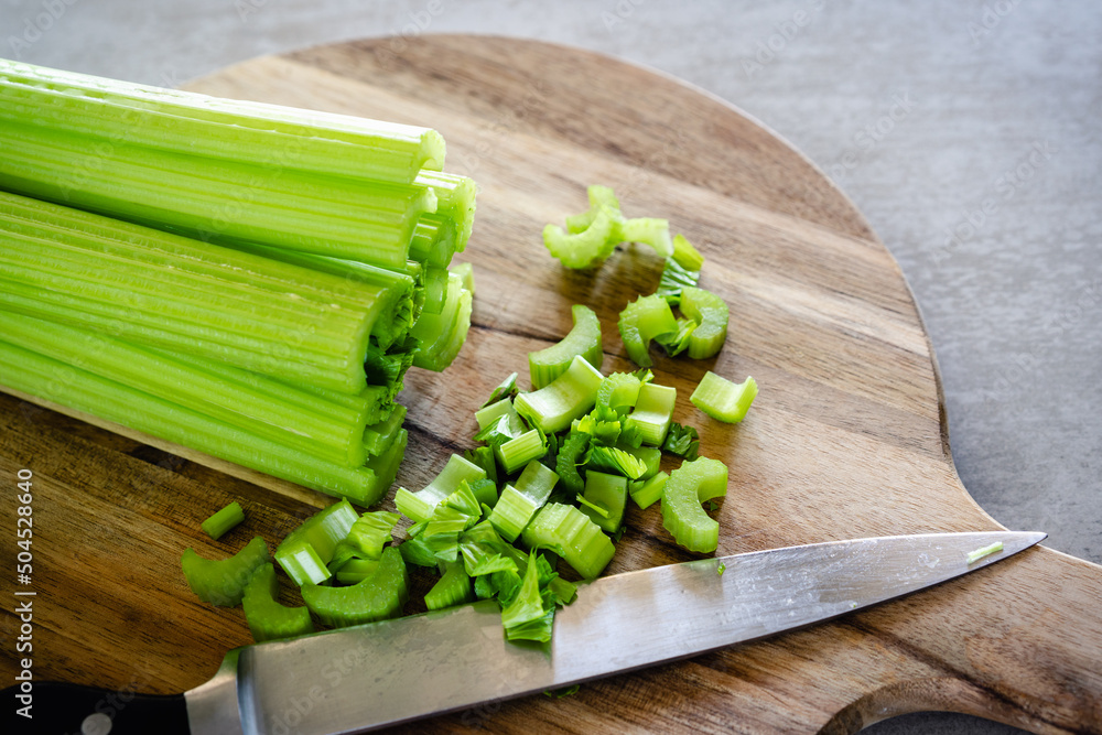 Celery stalks, stems on wooden cutting board, close up. Healthy eating, healthy lifestyle concept. Celery stalks, stems on wooden cutting board, close up. Healthy eating, healthy lifestyle concept.