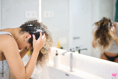Black female applying hair mousse