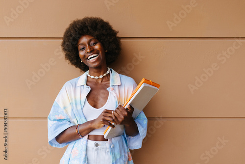 Cheerful black woman with notebook photo