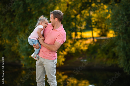 dad and little daughter 3 years old, play outside in the park, spend time together in summer