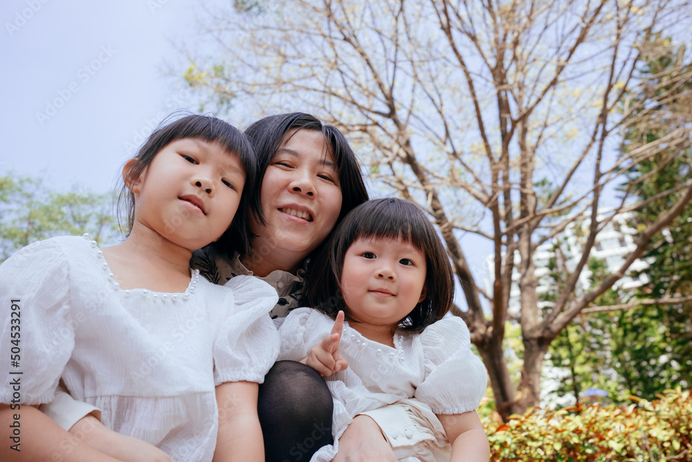 Outdoor family portrait of two cute little girls and mother Outdoor family portrait of two cute little girls and mother