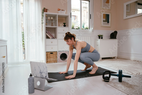 Sportswoman doing burpee exercise at home photo