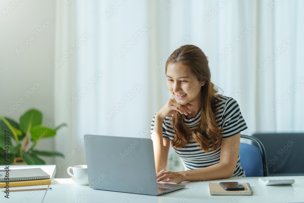 Portrait of young Asian business woman using laptop computer at home office. Portrait of young Asian business woman using laptop computer at home office.