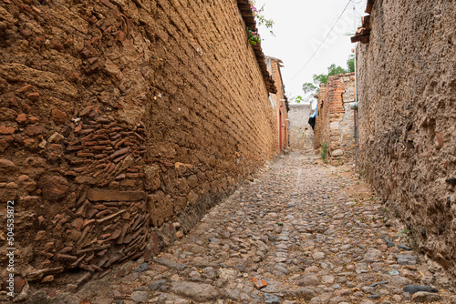 Vanishing point of a stone path in the middle of adobe houses photo