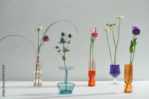 A closeup shot of four glass vases with different wildflowers