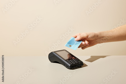 Anonymous person using credit card and payment terminal