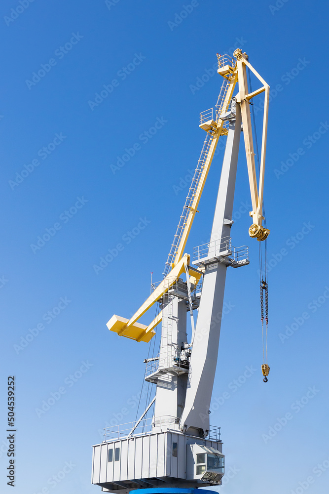 Close-up of port cargo crane against blue sky background Close-up of port cargo crane against blue sky background