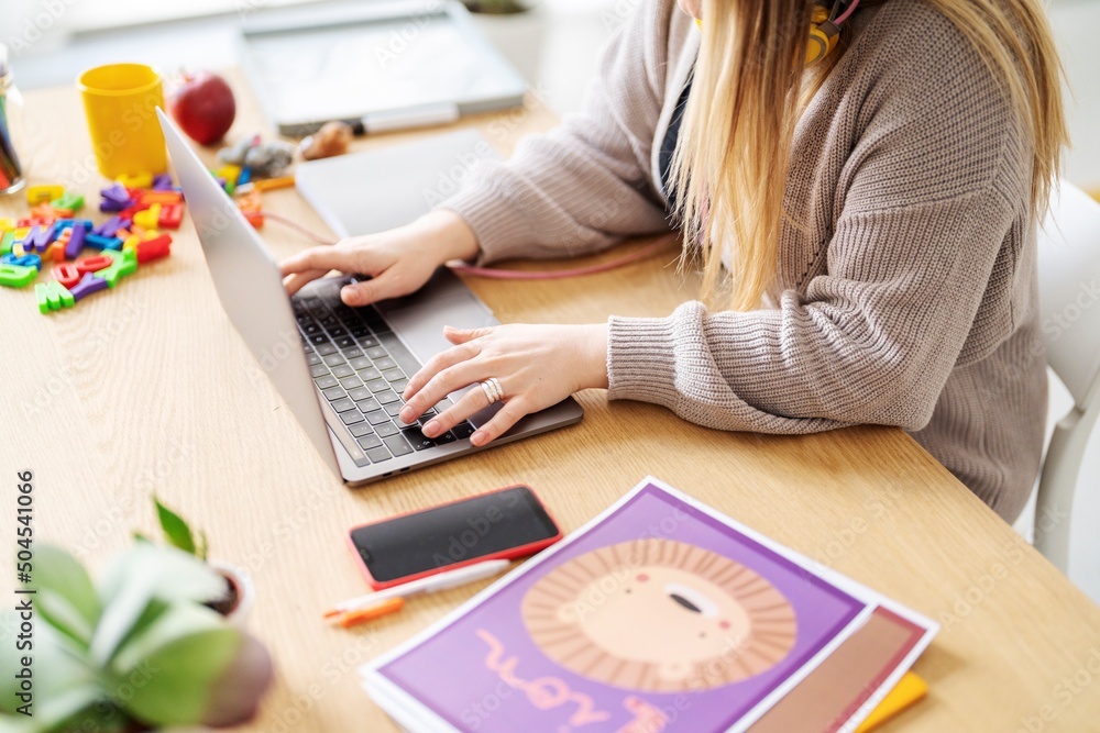 © Studio Marmellata/Stocksy - Crop teacher browsing laptop during distance lesson
