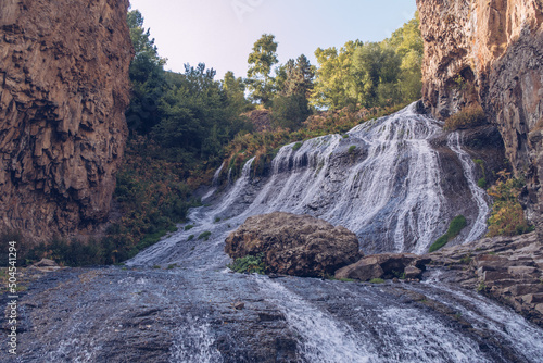 Jermuk waterfall flowing stream picturesque view among the canyon rocks sunlit gorge. Armenian stock photo