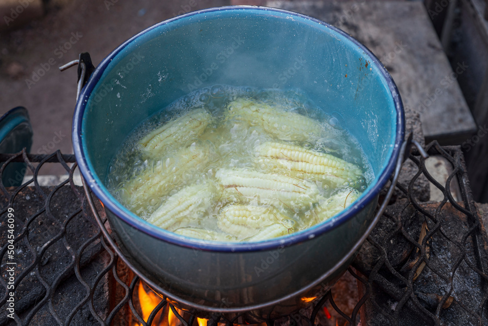 Blue pewter pot with yellow corn boiling inside Blue pewter pot with yellow corn boiling inside