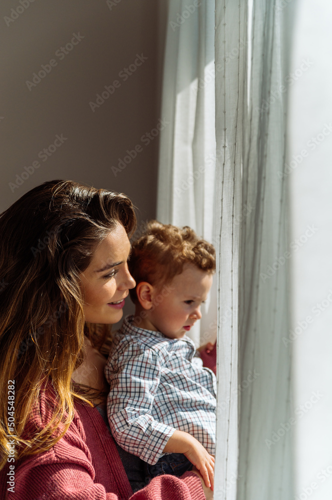 Mother and son near window at home Mother and son near window at home