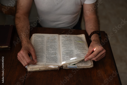 Man reading the bible at kitchen table.
