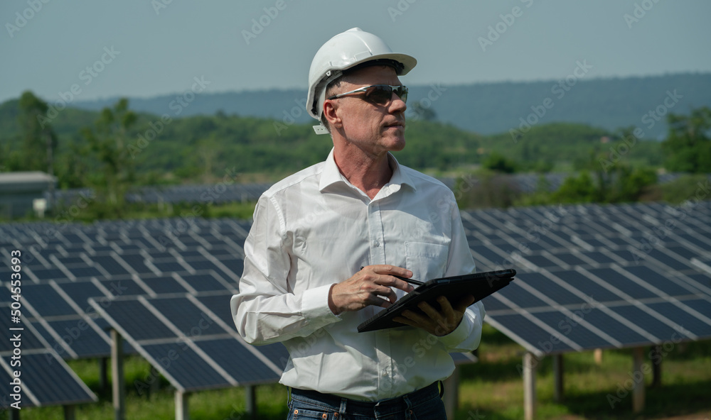 Obraz premium Concept: Renewable Energy. Team of engineers working to check the system through the phone. Photovoltaic for clean energy production. Innovate green energy for life on solar farms